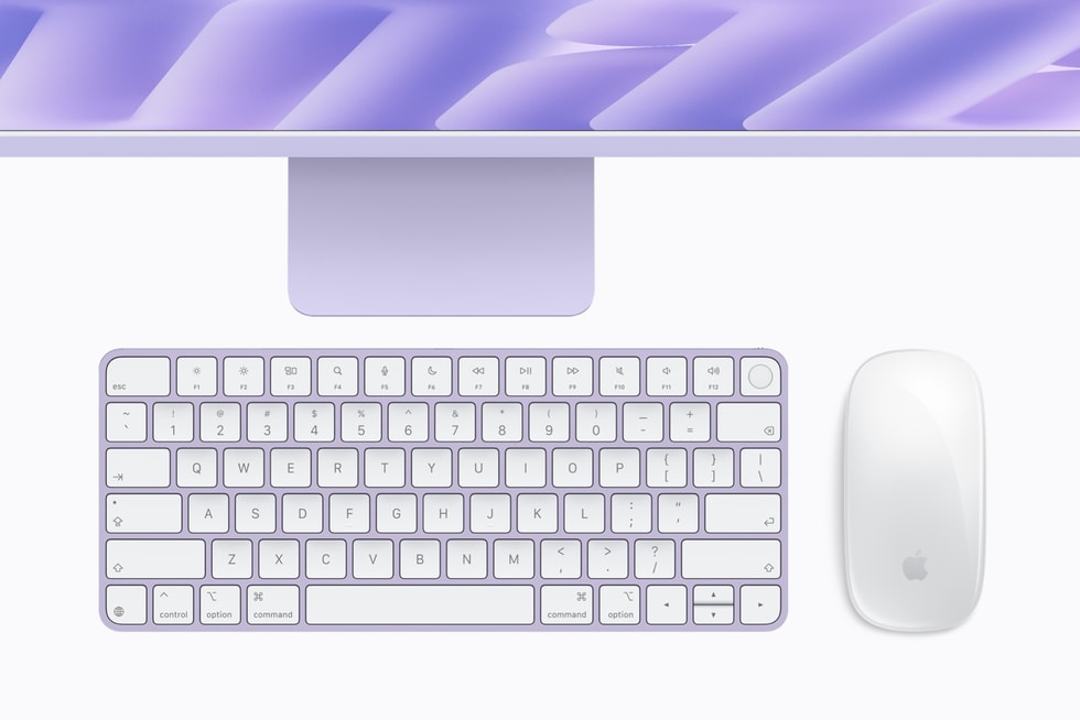 Teclado y mouse del mismo color debajo de un iMac con M6 morado