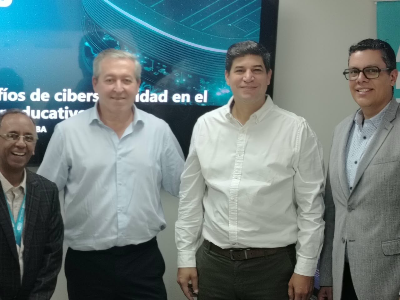 Cuatro participantes del Desayuno Tecnológico de ESET Venezuela frente a una pantalla sobre ciberseguridad en educación