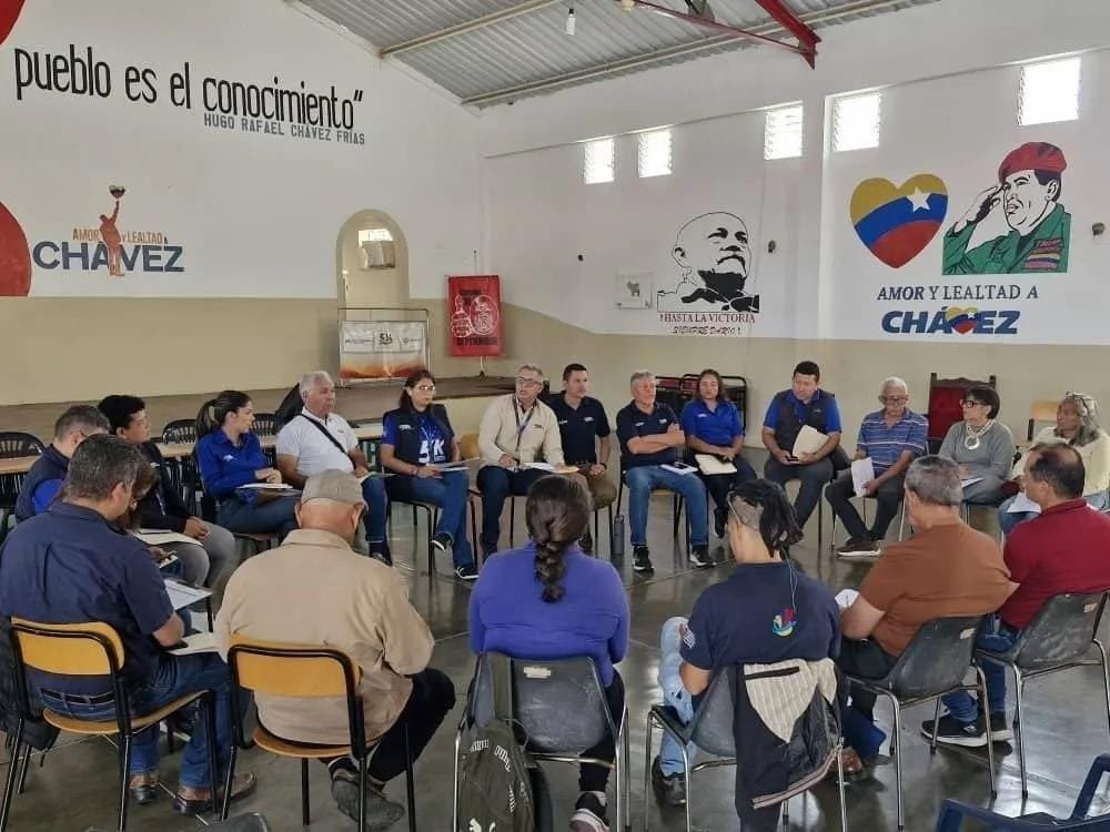 Voceros comunitarios y trabajadores de Cantv sentados en círculo en un salón durante una reunión